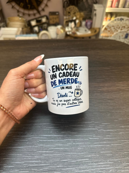Mug blanc humoristique pour un super collègue, inscription Encore un cadeau de merde et décor bleu